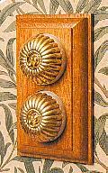 Arts & Crafts Movement style elegant fluted brass double domed switch electric light switch on medium Oak wooden backplate