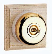 Arts & Crafts Movement style elegant brass single domed nipple electric light switch on square natural oak wooden backplate