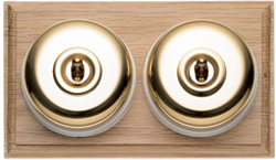 Arts & Crafts Movement style elegant brass double domed nipple electric light switch on light oak wooden backplate
